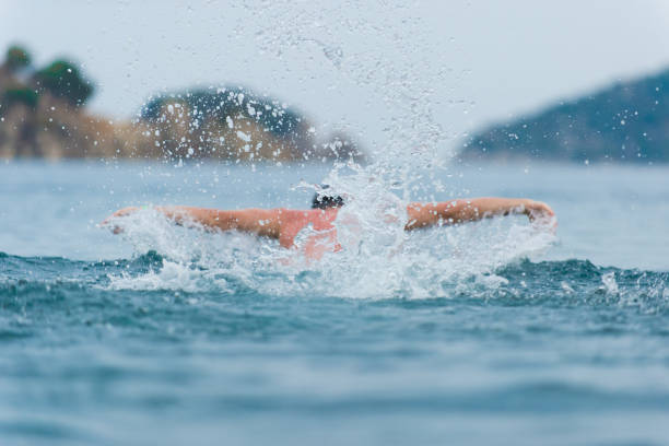istock young sporting man swims in the sea dolphin style. 932724710