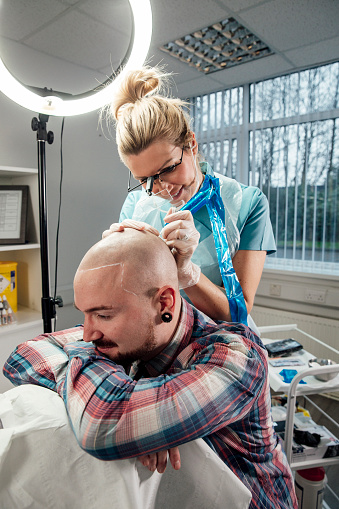 A man attends a medical clinic to receive scalp micro-pigmentation.