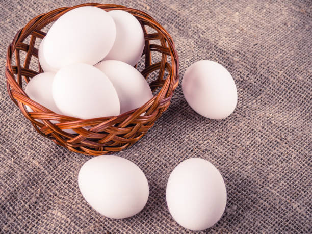 huevos frescos en una canasta de madera - animal egg eggs basket yellow fotografías e imágenes de stock