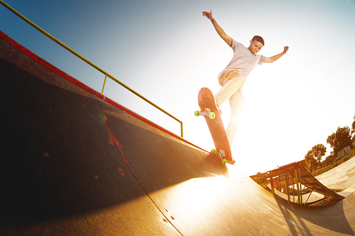 istock Teen skater hang up over a ramp on a skateboard in a skate park 932735258