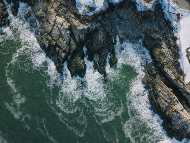 istock Aerial View of Waves Hitting Rocks 932735906