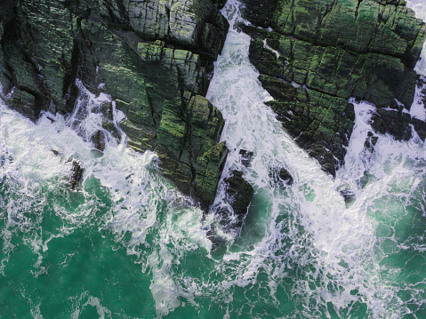 Aerial View of Waves Hitting Rocks