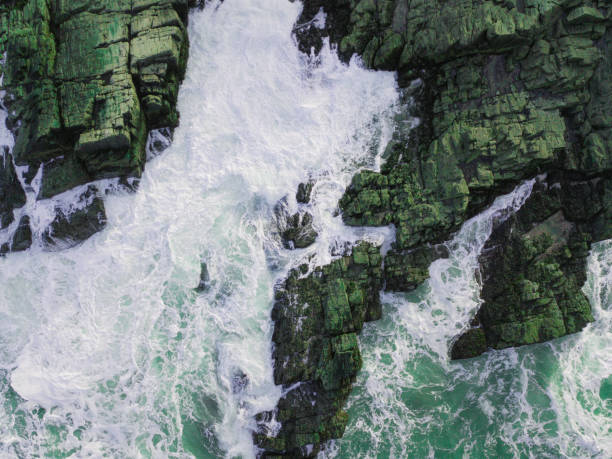 istock Aerial View of Waves Hitting Rocks 932737514