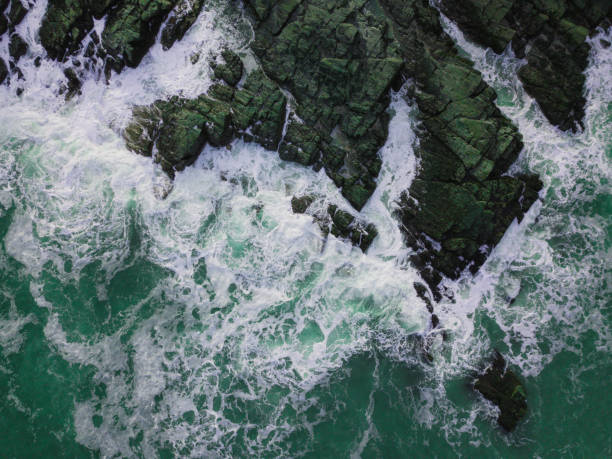 istock Aerial View of Waves Hitting Rocks 932738114