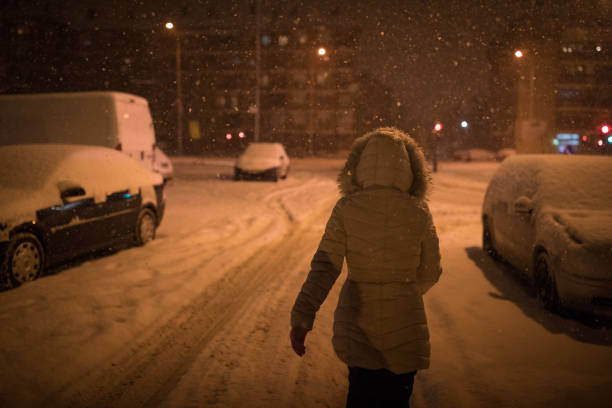 Woman walking at snowy evening