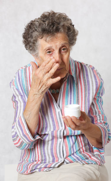istock Senior woman uses face cream 932750068