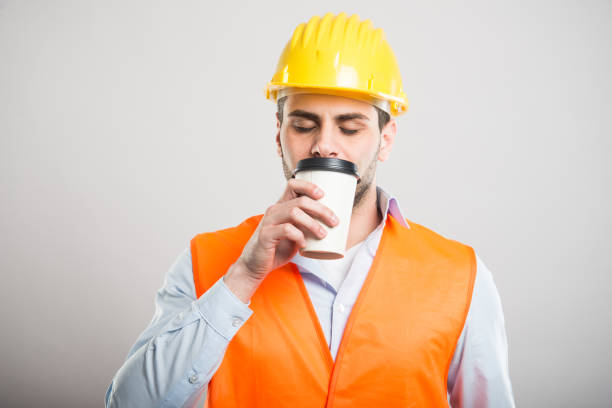 istock Portrait of architect smelling takeaway coffee cup 932750624