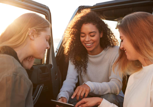 istock Female friends planning road trip route with tablet computer 932750924