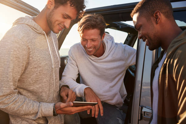 istock Male friends planning road trip route with tablet computer 932751198