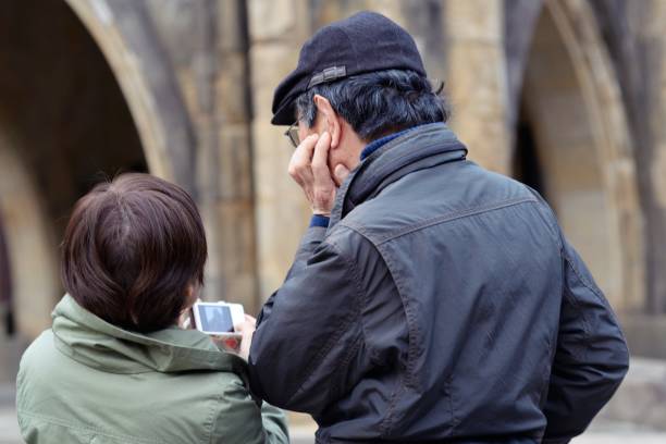 A mature couple looking at their camera after taking a photo.