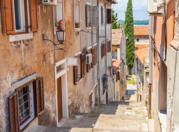 Pula, Croatia and old narrow street Narrow street with stairs down and typical houses in old town of Pula city in Croatia. croatian culture photos stock pictures, royalty-free photos & images