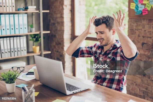 Wtf Omg Oh No Young Amazed Emotional Brunet With Bristle With Sad Grimace Looks At Screen Of Device He Cant Believe The Bad News He Received Sitting At Workstation Gesturing With Palms Of Arms Stock Photo - Download Image Now