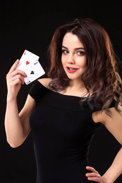 young woman playing in the gambling on black background - smiling casino human hand beautiful imagens e fotografias de stock