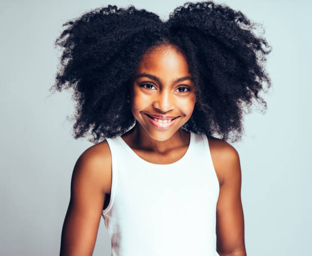 istock Cute Young African girl smiling confidently against a gray background 932764432