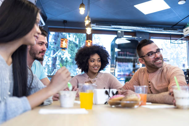 istock Young people talking and eating ice cream in cafeteria 932766702