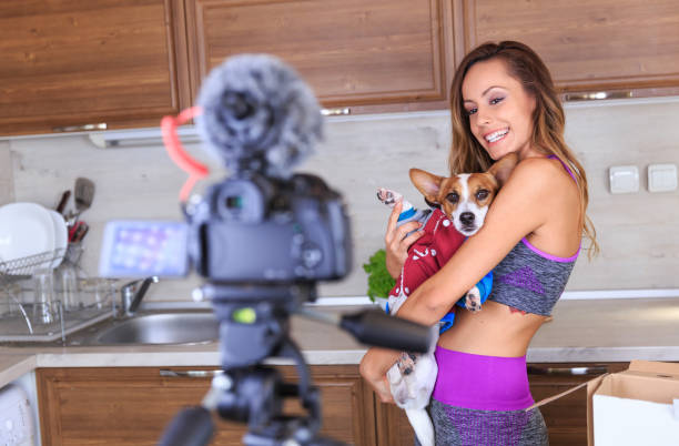 vlogger femelle making vidéo pour sportwears - dog pets advice women photos et images de collection
