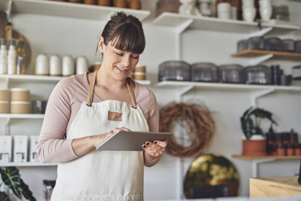 Young female florist using a digital tablet in her flower shop
