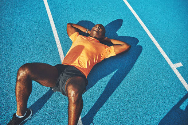 istock Fit young athletic lying on a running track after training 932771236