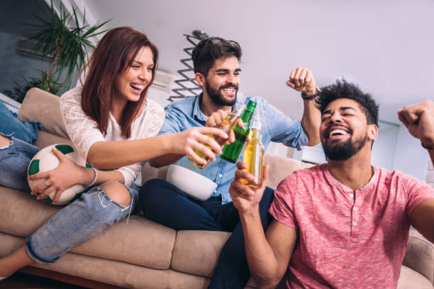 istock young friends having fun and drinking beer in home interior 932774582