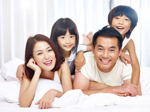 happy asian family having fun in bed happy asian family with two children having fun in bed at home. happy malay couple stock pictures, royalty-free photos & images