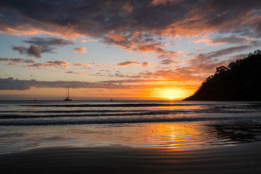 Boats silhouetted against the rising sun at Cape Tribulation, in Australia's North Queensland