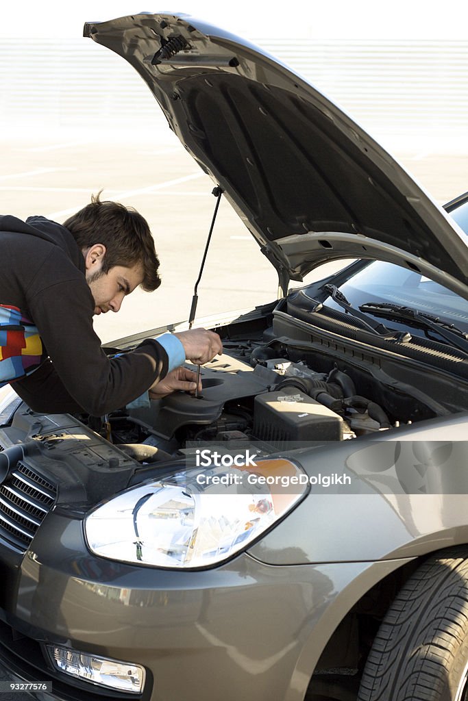 Car driver examining the car's engine  Adult Stock Photo