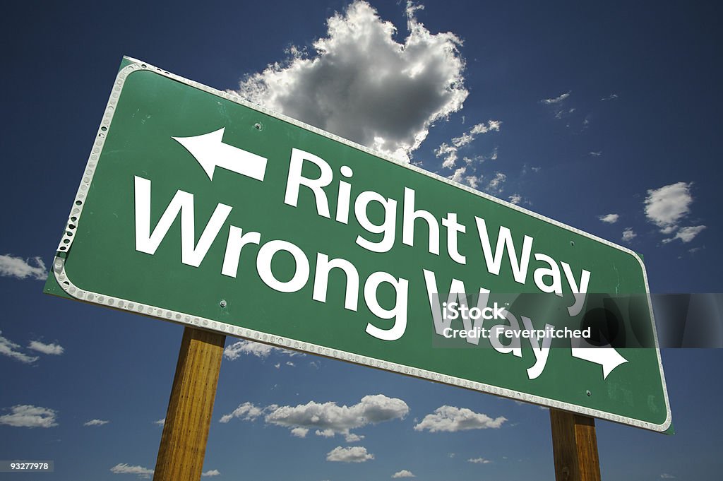 Right and Wrong Way Green Road Sign Right and Wrong Way Road Sign with dramatic blue sky and clouds. Aspirations Stock Photo