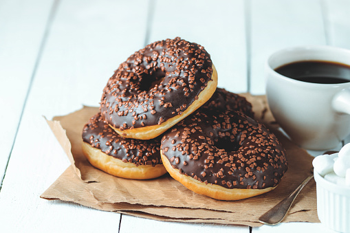 Chocolate donuts and coffee , weekend morning table breakfast. Vintage colors