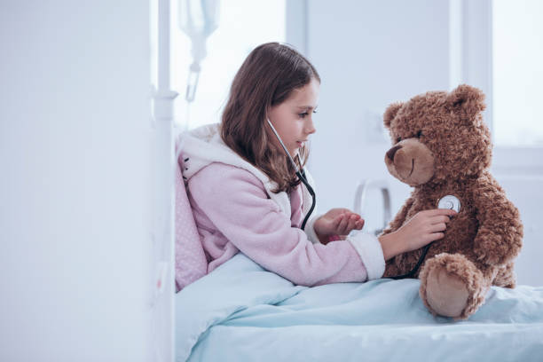 istock Girl examining teddy bear 932785904