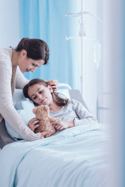 Child with toy Young child with toy lying on the hospital bed and spending time with her mother sick child hospital bed stock pictures, royalty-free photos & images