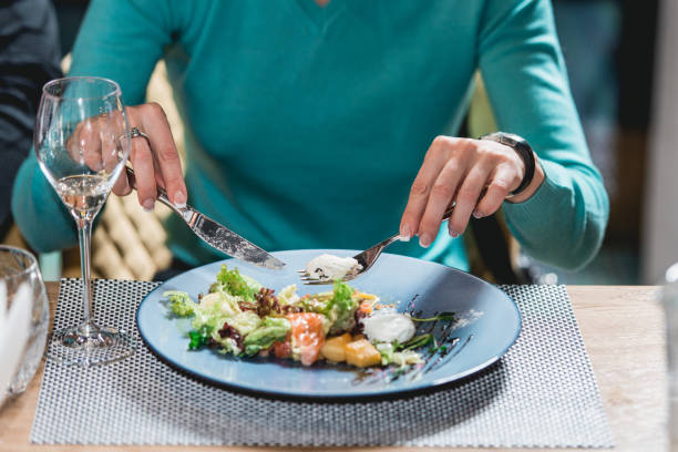 istock woman eats delicious salmon salad with egg in a restaurant. small portion 932789970