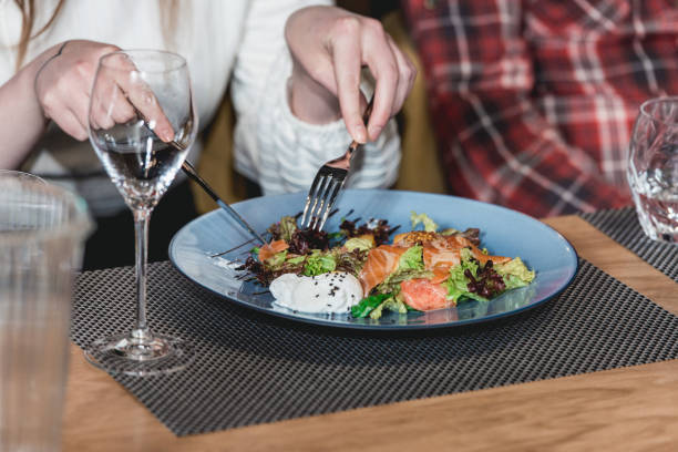 istock woman eats delicious salmon salad with egg in a restaurant. small portion 932790166