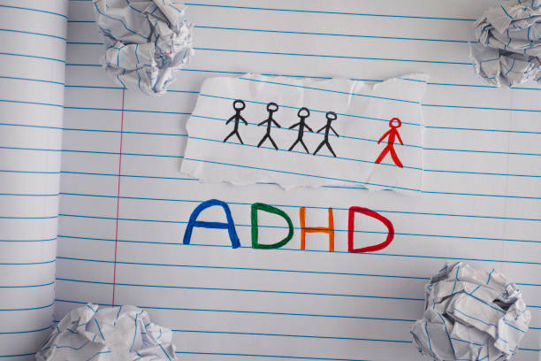 istock ADHD. Abbreviation ADHD on notebook sheet with some crumpled paper balls on it 932794734