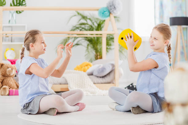 istock Twin sisters playing yellow ball 932797736