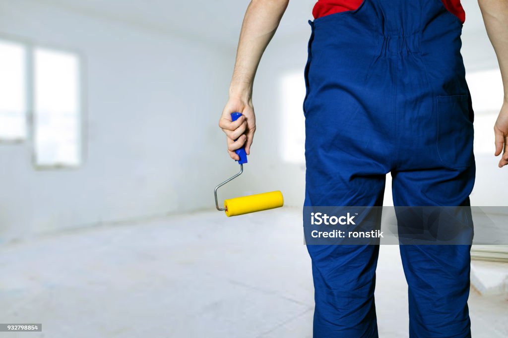 construction worker with paint roller ready for apartment painting Adult Stock Photo