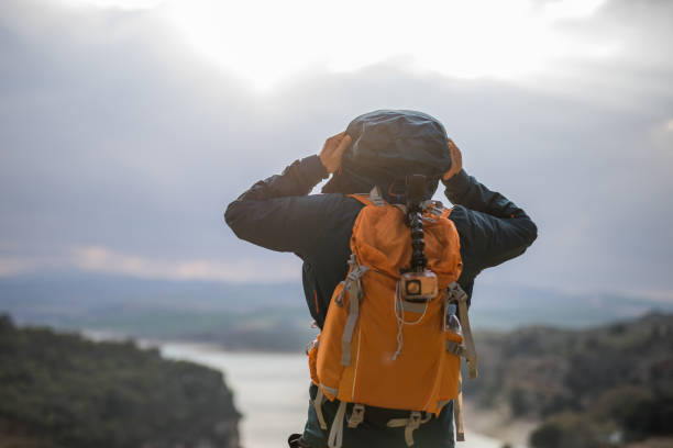 istock Hiker putting on hoodie 932799066
