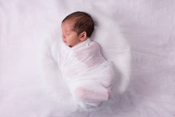 istock Newborn baby wearing white. 932802018