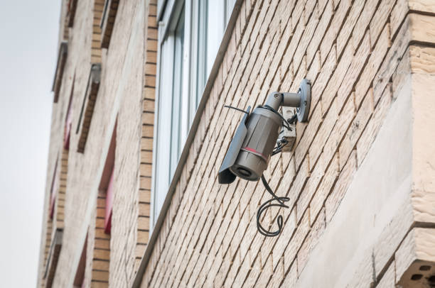 istock Small surveillance security cctv camera recording the street from the building facade wall for public safety 932806320