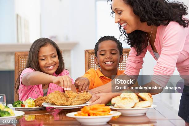 La Madre Que Sirve Una Comida Foto de stock y más banco de imágenes de Comer - Comer, Familia, Pollo frito