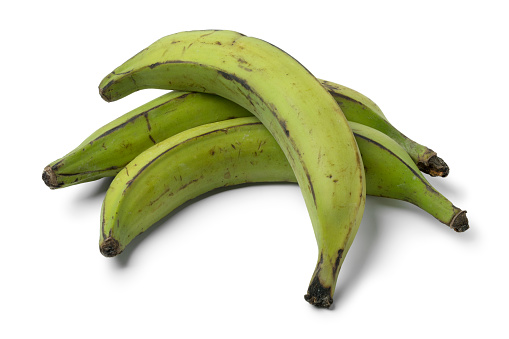 Whole green unripe bananas isolated on white background