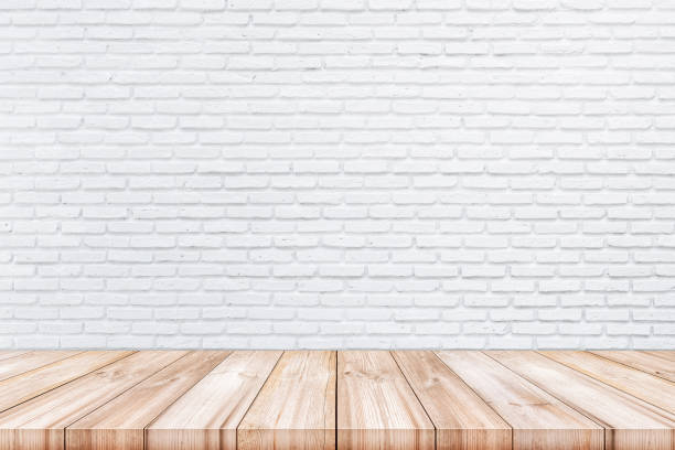 istock Empty wooden table top with white color brick wall background. 932815518