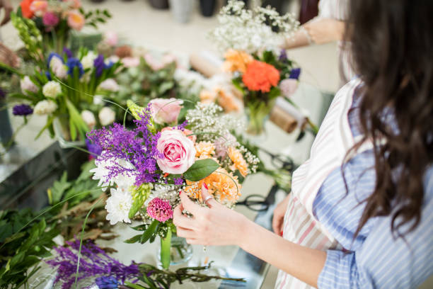 Woman making floral decorations Learning flower arranging, making beautiful bouquets with your own hands florist stock pictures, royalty-free photos & images
