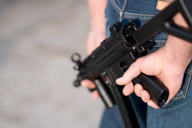 istock Cropped image of a man holding a rifle 932816572