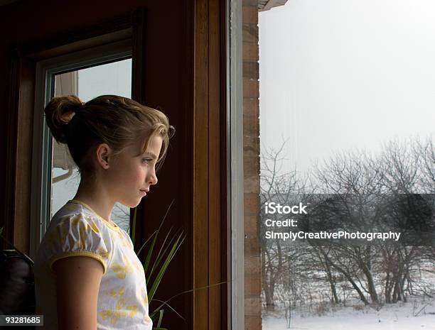 Young Girl Contempla Fuera De La Ventana De Invierno Foto de stock y más banco de imágenes de Mirar por la ventana