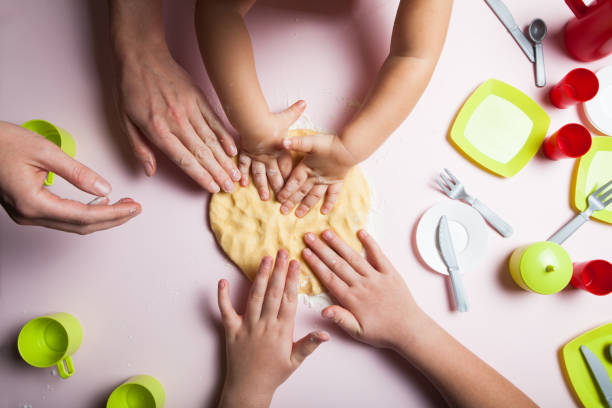 istock Mom teaches young children how to cook. 932830538