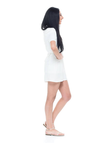 istock Cute young lady in white dress with hand on hips 932831658