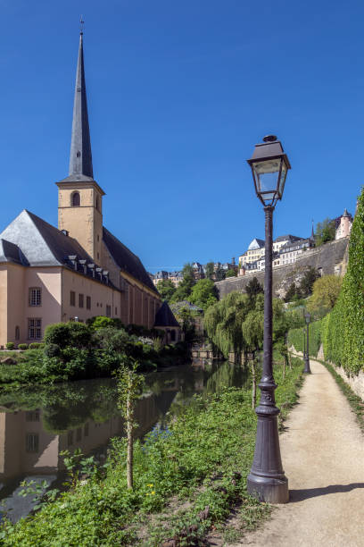 St John Neimenster - Luxembourg City in the Grand Duchy of Luxembourg Luxembourg City or Ville de Luxembourg in the Grand Duchy of Luxembourg. St John Neimenster and part of the walls of the old town viewed from the Grund area of the city. petrusse stock pictures, royalty-free photos & images