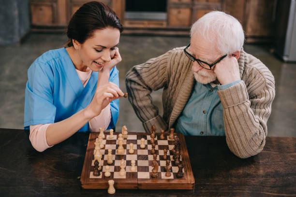 istock Top view of nurse and elder man playing chess 932837806