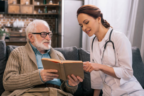 istock Doctor and senior man reading book on sofa 932841382