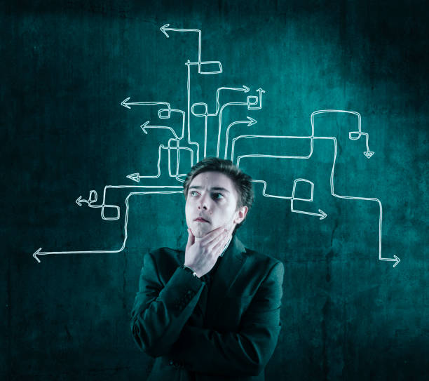 istock Thoughtful businessman next to a wall painted with arrows from his head. 932842058